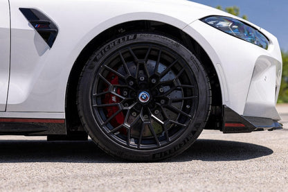 BMW floating centre cap fitted on a black alloy wheel of a white car