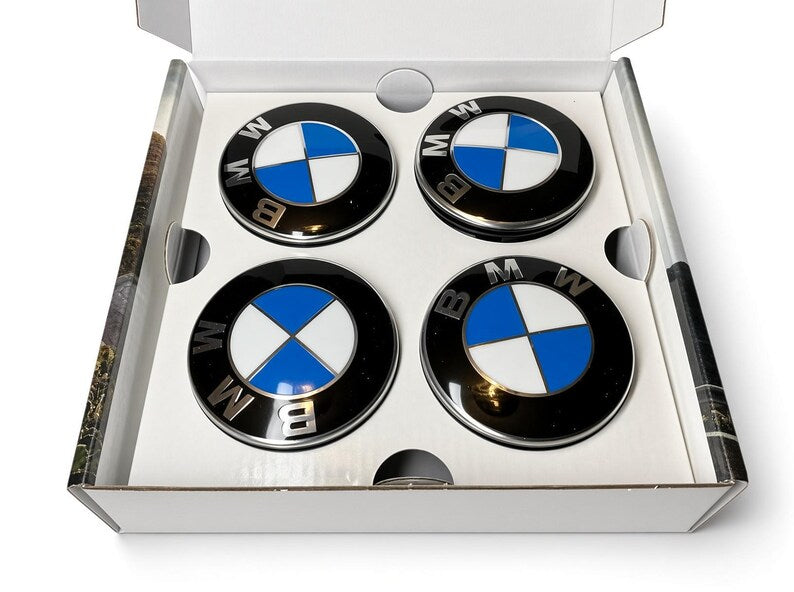 Four BMW floating centre caps with blue and white roundel in open white box