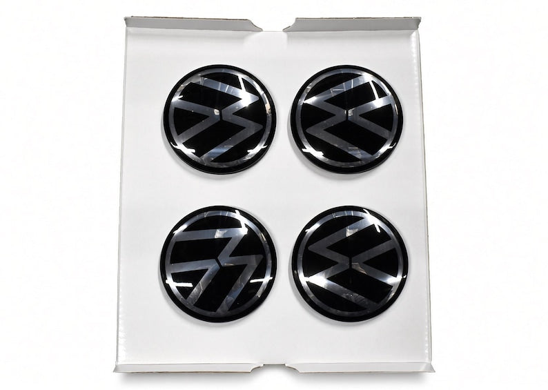 Four black floating centre caps with VW logo in white gift box
