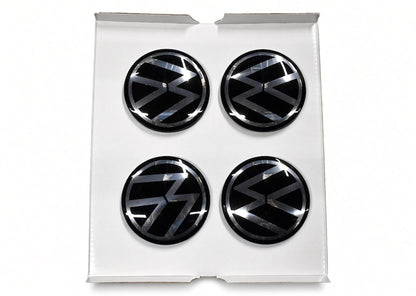 Four black floating centre caps with VW logo in white gift box